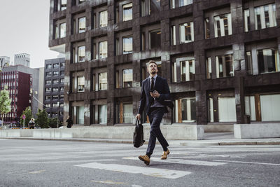 Male entrepreneur looking up while crossing street