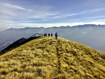 Group of hikers on hill against mountain range