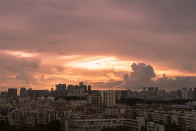 Buildings in city against sky during sunset