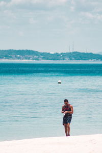 Man standing on beach against sky