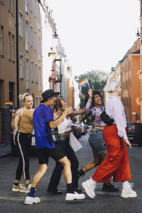 Happy young lgbtqia friends walking while enjoying on road