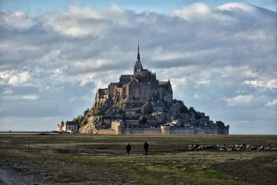 People walking towards mont saint-michel