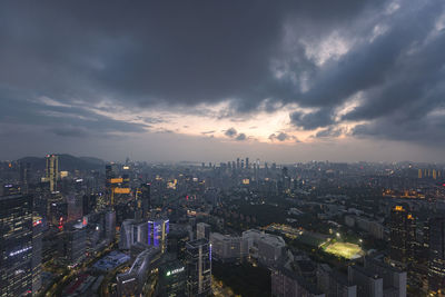 High angle view of illuminated city buildings against sky