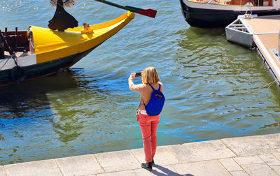 Rear view of woman standing in boat