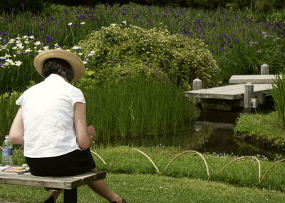 Rear view of man walking on grassy field in park