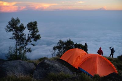 A climber enjoying the sunrise not far from his tent on mount sumbing