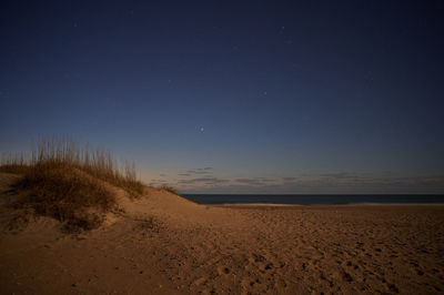 Scenic view of beach against sky at night