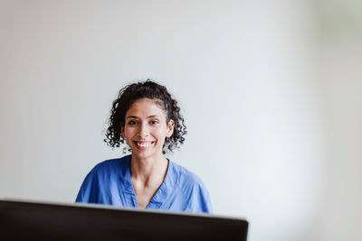 Portrait of a smiling young woman using phone