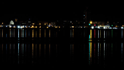 Illuminated cityscape against sky at night