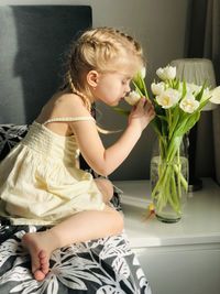 Midsection of woman sitting on sofa at home