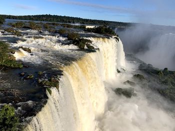 Scenic view of waterfall against sky