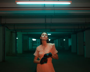 Young woman standing against illuminated lights