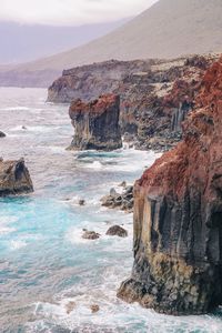 Red volcanic cliffs in the ocean