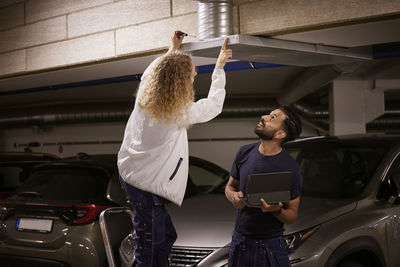 Man and woman checking air duct