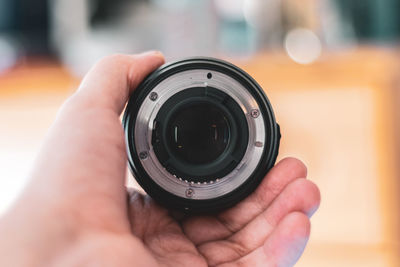 Close-up of hand holding camera lens