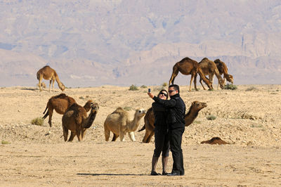 Full length of man photographing on sand