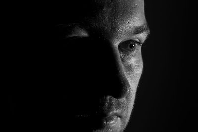 Close-up of man against black background