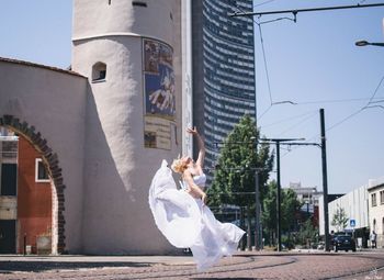 Woman with umbrella against buildings in city