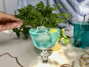 Blue cold drink in a glass with ice cubes