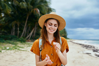 Portrait of smiling young woman standing on beach