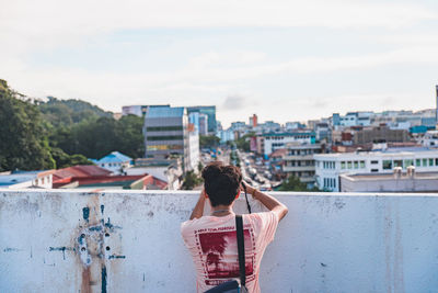 Rear view of woman looking at cityscape