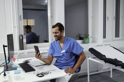 Male doctor having online consultation on smart phone