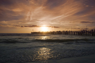 Scenic view of sea against cloudy sky during sunset