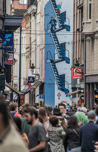 People walking on street against buildings in city