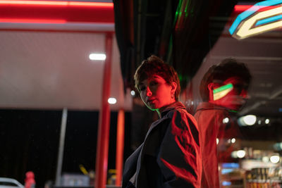 European woman is standing near with market windshield in which lighting fixtures are reflected