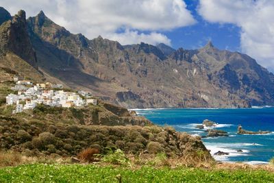 Scenic view of mountains and sea against cloudy sky