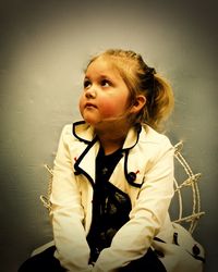 Close-up of cute girl standing against wall