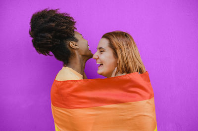 Side view of young woman against blue background