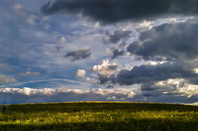 Scenic view of field against cloudy sky