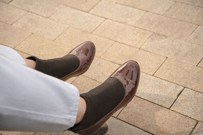 Low section of woman with high heels on footpath