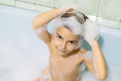 Portrait of girl taking bath in bathroom