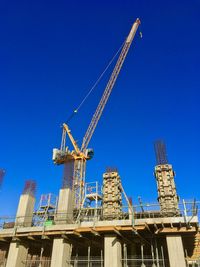 Low angle view of crane against building