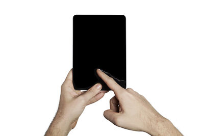 Close-up of hand using mobile phone against white background