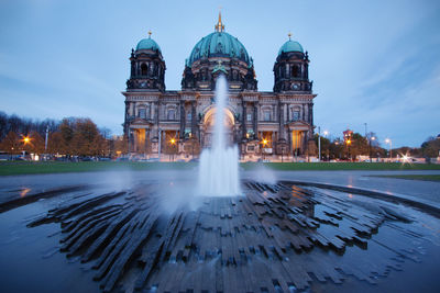 Fountain in city against building