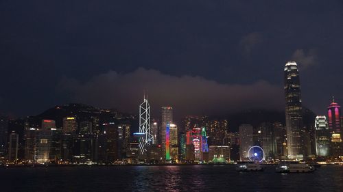 Illuminated buildings in city against sky at night