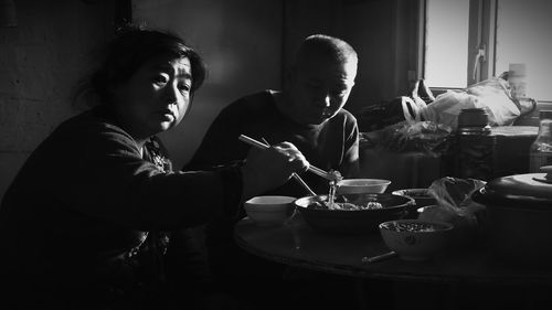 Couple having food on table at home