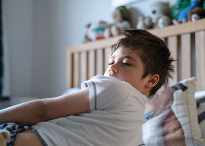 Cute boy lying on bed at home