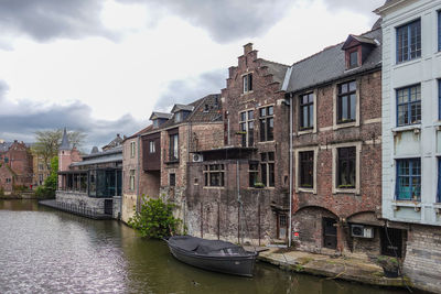 Canal amidst buildings against sky