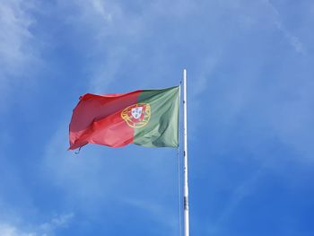 Low angle view of flag against blue sky