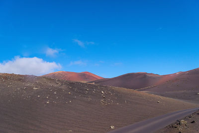 Scenic view of desert against blue sky