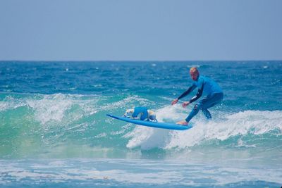 Man surfing in sea against clear sky