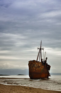 Abandoned ship in sea against sky