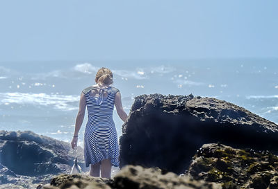 Rear view of woman looking at sea against sky