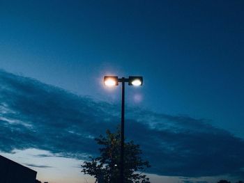 Low angle view of illuminated street light against blue sky