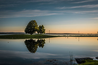 Scenic view of lake against sky at sunset