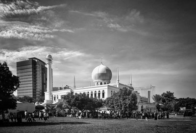 Group of people in front of building against sky